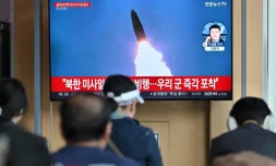 Des personnes devant un écran de télévision montrant des images d'archive d'un essai de missile nord-coréen, dans une gare de Séoul, en Corée du Sud, le 22 avril 2024