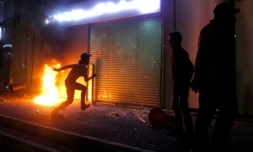 Un manifestant libanais devant l'entrée d'une banque en flammes à Saïda, le 29 avril 2020