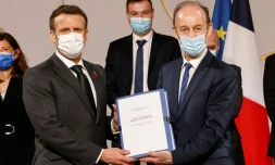 L'historien français Vincent Duclert remet au prĂ©sident français Emmanuel Macron (g) un rapport sur la politique française au Rwanda entre 1990 et 1994 dans la salle des fĂȘtes du palais de l'ElysĂ©e Ă Paris, le 26 mars 2021