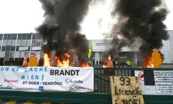 Des palettes brĂ»lent devant l'usine Brandt oĂč sont rassemblĂ©s des employĂ©s, le 11 dĂ©cembre 2025 Ă VendĂŽme, dans le Loir-et-Cher