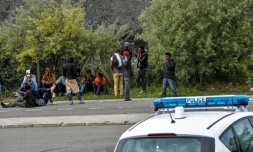 Des policiers face à des migrants sur une route menant à Calais, le 16 août 2017 