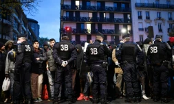 Des policiers entourent des migrants pendant l'évacuation du camp installé entre les stations de métro Stalingrad et Jaurès à Paris le 4 novembre 2016
