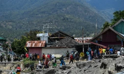 Des habitants marchent le 2 octobre 2018 au milieu des décombres dans le village de Perumnas Balaroa (Indonésie).