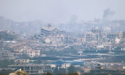 Une photo prise depuis  la frontière israélienne avec la bande de Gaza montre dees destructions et de la fumée s'élevant au dessus du territoire palestinien après des raids israéliens, le 18 mai 2025
