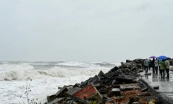 Des passants le long de la cĂŽte du golfe du Bengale, Ă Kakinada, en Inde, le 27 octobre 2026, avant le passage attendu du cyclone Arnab