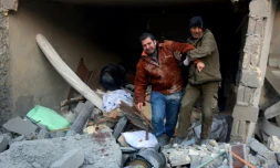 Deux syriens sortent des décombres d'un immeuble après des bombardements dans le quartier d'al-Hamra à Alep, tenu par les rebelles, le 20 novembre 2016 