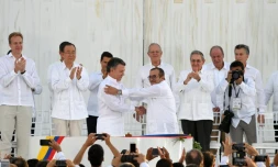 Le président colombien Juan Manuel Santos (G au centre serre la main du chef des Farc, Timoleon Jimenez, alias Timochenko (D au centre) scellant l'accord de paix historique