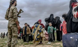 Un combattant des Forces démocratiques syriennes encadre des femmes et des enfants évacuées de Baghouz, le 27 février 2019 