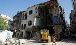 Des ouvriers enlèvent les décombres sous un bâtiment partiellement détruit par l'explosion dans le port de Beyrouth, le 26 août 2020 au Liban