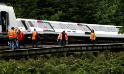 Des employés de la SNCF près d'un RER qui a déraillé entre Saint-Rémy-les-Chevreuse et Courcelle-sur-Yvette le 12 juin 2018