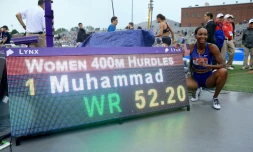 Dalilah Muhammad (d) pose à cÎté du panneau affichant son record du monde du 400 m haies aux Chpts des Etats-Unis, le 28 juillet 2019 à Des Moines dans l'Iowa