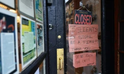 "3 clients à la fois maximum dans la boutique", prévient une affichette accrochée sur la vitrine d'un boucher de Brooklyn, à New York, le 20 mars 2020