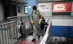 Un employé muni d'un masque de protection vaporise un produit désinfectant dans une station de métro, à Pékin le 31 janvier 2020