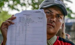 Akhmad, ancien membre d'Ă©quipage d'un navire de pĂȘche chinois, montre son contrat et son salaire mensuel lors d'un entretien avec l'AFP au port du hameau de Bungko Lor, Ă Cirebon, le 10 juin 2026 en IndonĂ©sie