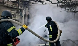Photo diffusée par le service d'urgence de l'État ukrainien, le 18 mai 2025, de sauveteurs éteignant un incendie dans un bâtiment à la suite d'attaques de drones russes sur la région de Kiev