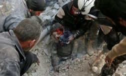 Des Casques blancs de la Défense civile syrienne sauvent un enfant des décombres d'un bâtiment détruit par un bombardement, à Bab al-Nairab, dans le nord d'Alep, le 24 novembre 2016