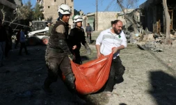 Des Casques blancs syriens transportent le corps d'une victime après une frappes aériennes du régime, le 19 novembre 2016 à Alep