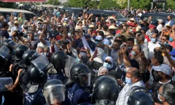 Des forces de sécurité repoussent des manifestants devant le Parlement, à Tunis, le 26 juillet 2021