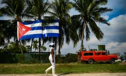 Une femme passe devant un drapeau cubain Ã  La Havane, le 1er fÃ©vrier 2022
