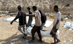Le corps d'un migrant retrouvé mort parmi d'autres sur une plage près de Zawiyah en Libye, emmené le 22 février 2017 par des secouristes 
