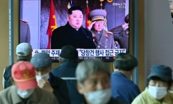 Des passants regardent la télévison qui diffuse des images d'archives du leader nord-coréen Kim Jong Un dans une gare de Séoul le 10 octobre 2020