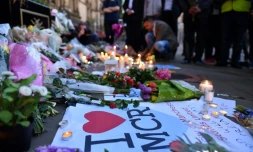 Des personnes déposent des fleurs et des bougies en mémoire aux victimes de l'attentat de Manchester, le 23 mai 2017 à Manchester