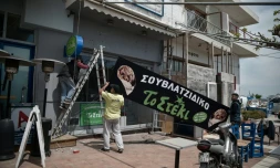 Des employés travaillent à la réouverture d'un restaurant dans le port de Rafina, le 29 avril 2020, prÚs d'AthÚnes, en GrÚce