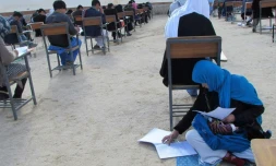 Cette photographie devenue virale en Afghanistan, obtenue depuis le compte Facebook du professeur afghan Yahya Erfan et prise le 16 mars 2018, montre Jahantab Ahmadi passant un examen d'entrée à l'université assise par terre avec son bébé