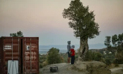 Deux migrants patientent aux abords du camps de Moria, sur l'île de Lesbos, en Grèce, le 25 septembre 2018