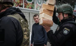 Des officiers de police ukrainiens livrent du pain, le 2 mai 2022, aux résidents restés dans la ville de Lyman à l'est de l'Ukraine malgré l'offensive des troupes russes