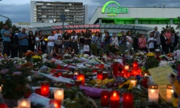 Des gens se recueillent prĂšs du centre commercial Olympia-Einkaufszentrum, en hommage aux victimes de la fusillade, le 24 juillet 2016 Ă Munich