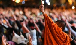 Des manifestants pro-démocratie, dont un moine bouddhiste, lèvent trois doigts en signe de résistance, le 18 octobre 2020 à Bangkok