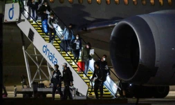 Joueurs de tennis et officiels descendent de leur avion à l'aéroport de Melbourne, le 14 janvier 2021
