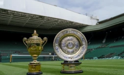 Les trophées qui seront remis aux vainqueurs en simples messieurs (g) et simples dames au tournoi de Wimbledon, sont exposés sur le court central, le 26 juin 2021 à Londres, à la veille de l'ouverture du 3e tournoi du Grand Chelem de l'année