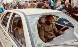 Un Palestinien conduit sa voiture endommagée lors d'un bombardement israélien, le 23 décembre 2023 à Rafah, dans la bande de Gaza