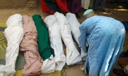 Un habitant enveloppe des cadavres avec des linceuils après une attaque de bandits dans la province de Zamfara au Nigéria, le 18 juin 2013
