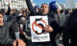 Un Algérien brandit une pancarte contre le 5e mandat que brigue le président Abdelaziz Bouteflika, lors d'une manifestation à Alger le 22 février 2019