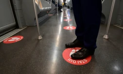 Une rame du métro de Milan avec un autocollant au sol portant l'inscription "Mettez-vous ici", le 28 avril 2020