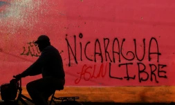 Un cycliste passe devant un graffiti réalisé au cours des manifestations contre le président Daniel Ortega, à Diriamba, à 40 km de Managua, le 124 juin 2018.