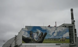 La centrale nucléaire de Tchernobyl et, en arriÚre plan, une partie du nouveau confinement de sécurité, un dÎme métallique recouvrant le sarcophage du quatriÚme réacteur détruit lors de l'invasion russe de l'Ukraine, le 9 avril 2026 à Tchernobyl