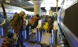 Des voyageurs passent des portes d'embarquement destinées à lutter contre la fraude à la gare Montparnasse le 3 avril 2017 à Paris