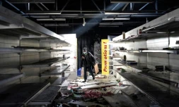 Un homme parcourt es rayons d'un supermarché pillé et incendié, à Dakar, le 6 mars 2021.