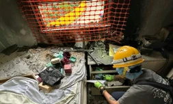 Sur cette photo prise et transmise le 23 avril 2026 par Bowie Chan, un habitant de Wang Fuk Court, son épouse Annie Tse fouille les tiroirs d'un meuble de leur appartement endommagé par l'incendie de novembre, à Hong Kong