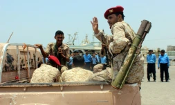Un rebelle Houthi fait un signe de la main lors du retrait annoncé de troupes rebelles du port de Salif, au Yémen, le 11 mai 2019