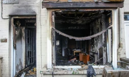 L'entrée et la fenêtre d'une maison brûlées après une deuxième nuit d'émeutes visant des immigrés à Ballymena, le 11 juin 2025 en Irlande du Nord