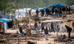 Des migrants s'activent pour remettre de l'ordre dans la "Jungle" de Calais le 27 mai 2016 au lendemain d'une importante rixe qui a fait 40 blesséz