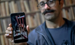 Farhad Sheikhi, un Kurde iranien qui a rejoint les manifestations antigouvernementales en 2022, montre des images des manifestations en Iran lors d'une interview à Souleimaniyeh, le 12 mars 2026 en Irak