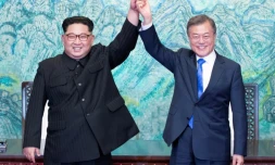 Le président sud-coréen Moon Jae-in (d) et le leader nord-coréen Kim Jong Un main dans la main à l'issue du sommet intercoréen, le 27 avril 2018 à Panmunjom