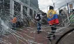 Un manifestant indigène enveloppé d'un drapeau équatorien près d'une barricade au voisinage de l'Assemblée nationale, à Quito le 26 juin 2022