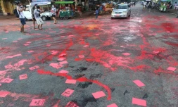 Photo fournie par une source anonyme de manifestants à Rangoun, le 10 avril 2021 maculant la rue de peinture rouge et distribuant des flyers pour dénoncer le coup d'état militaire